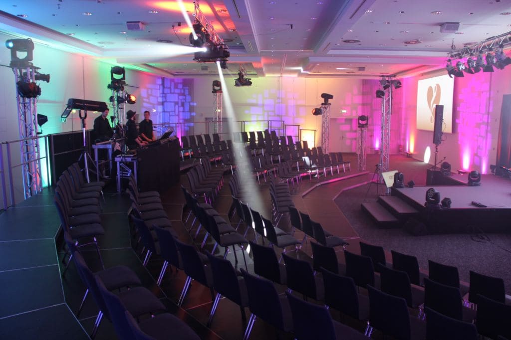Große Sitztribüne vor einer Bühne bei einer Veranstaltung im Innenbereich