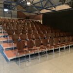 Zuschauertribüne Praktikus 750 in großer Halle mit Bestuhlung in Holz Optik